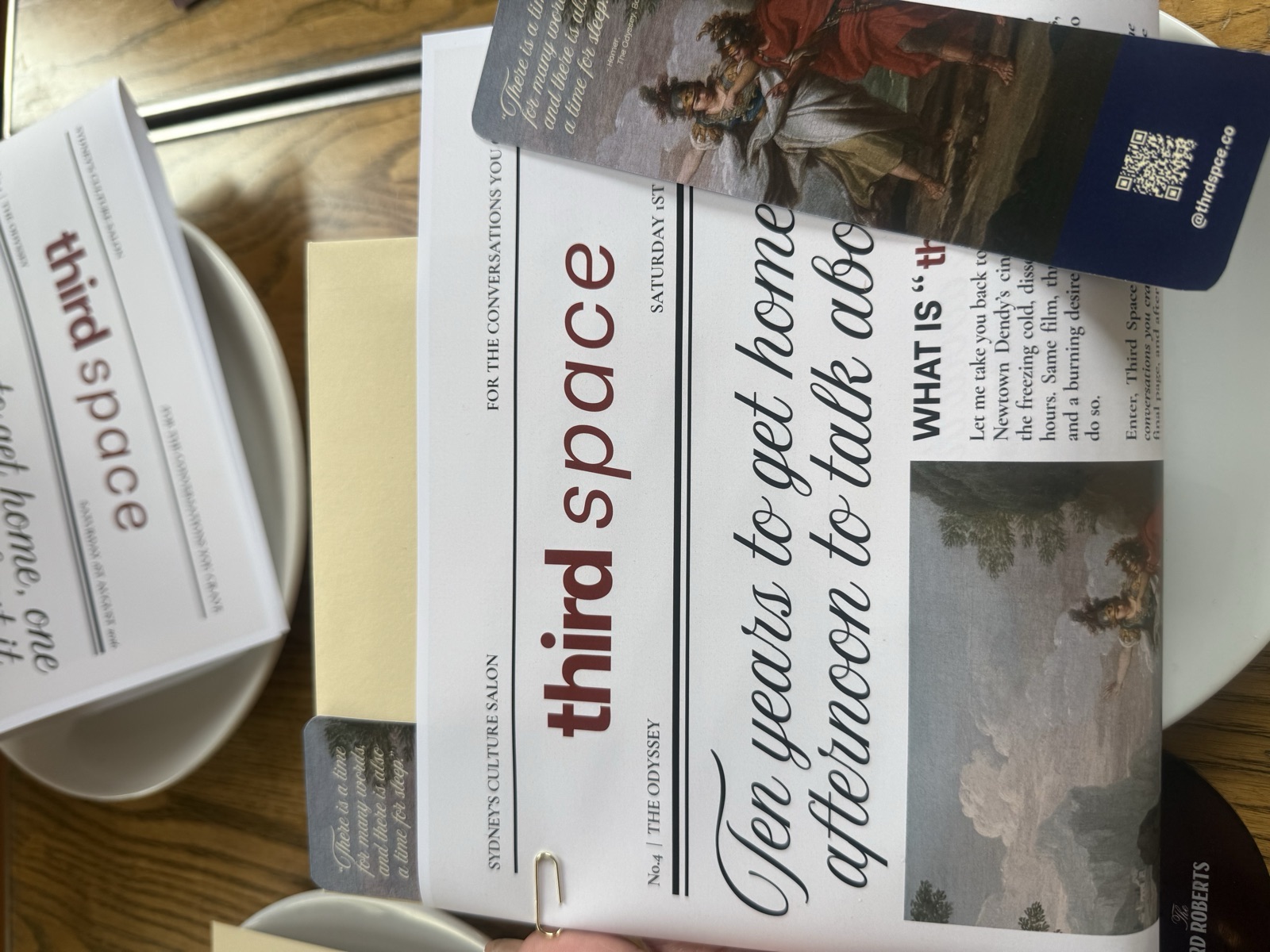 Third Space's printed newsletter and conversation cards laid out on a cafe table